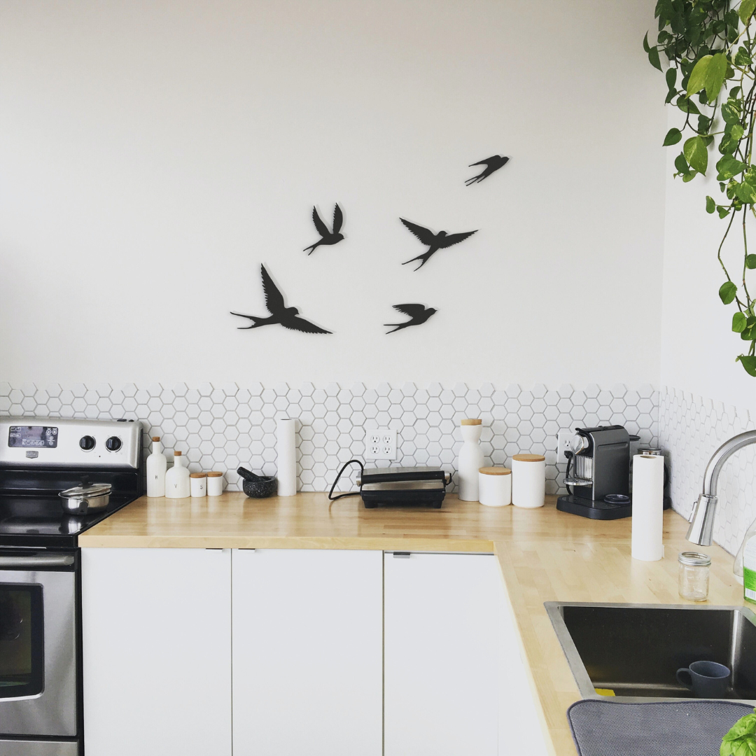 five black birds metal wall art on wall in kitchen