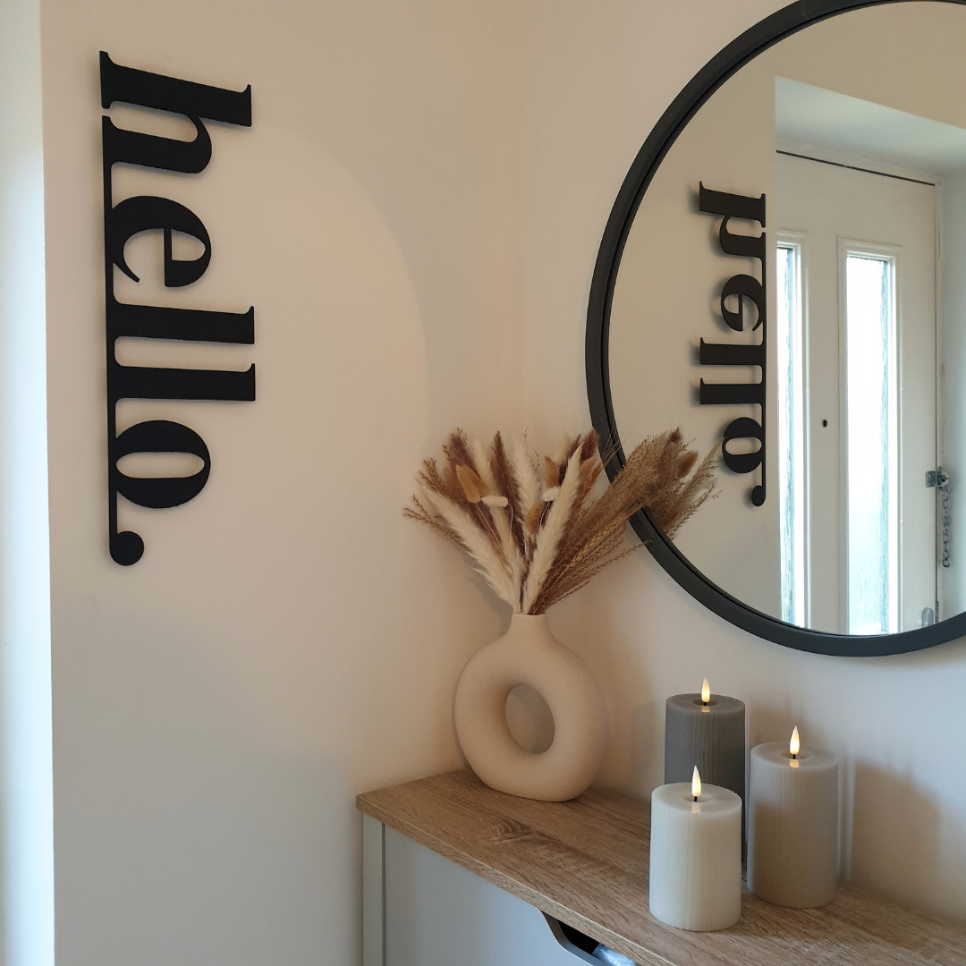 black hello metal sign on wall in hallway