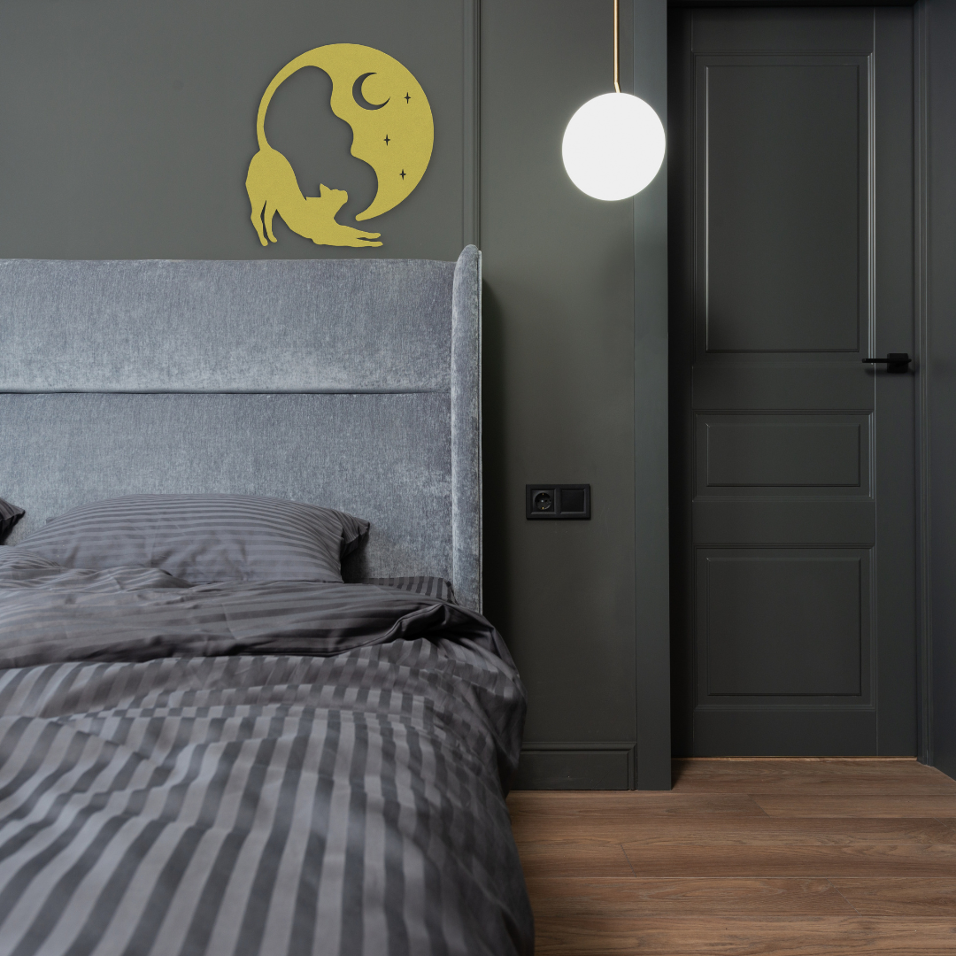 gold cat and moon metal wall art hanging on wall in bedroom
