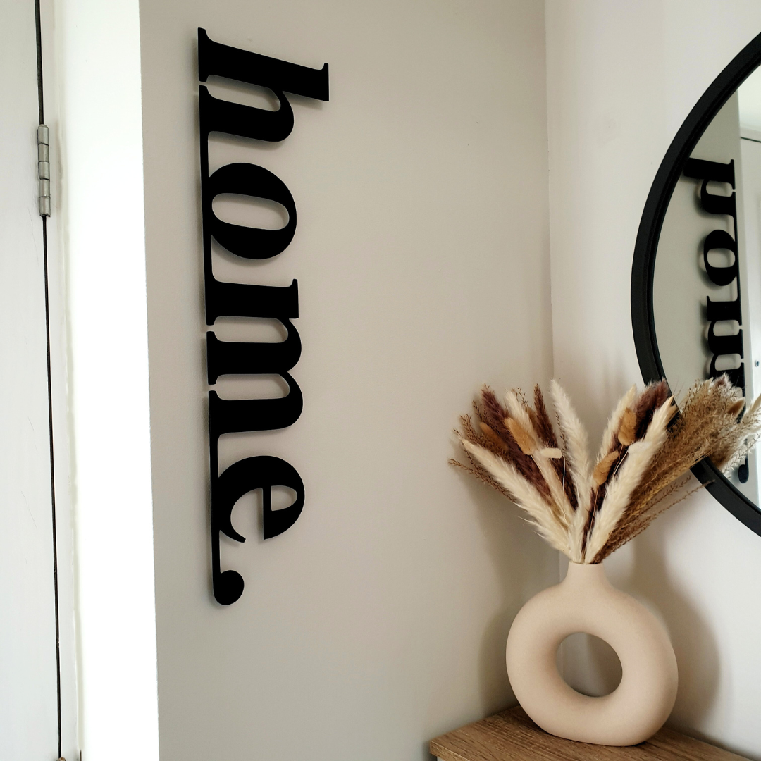 black home metal sign on wall in hallway