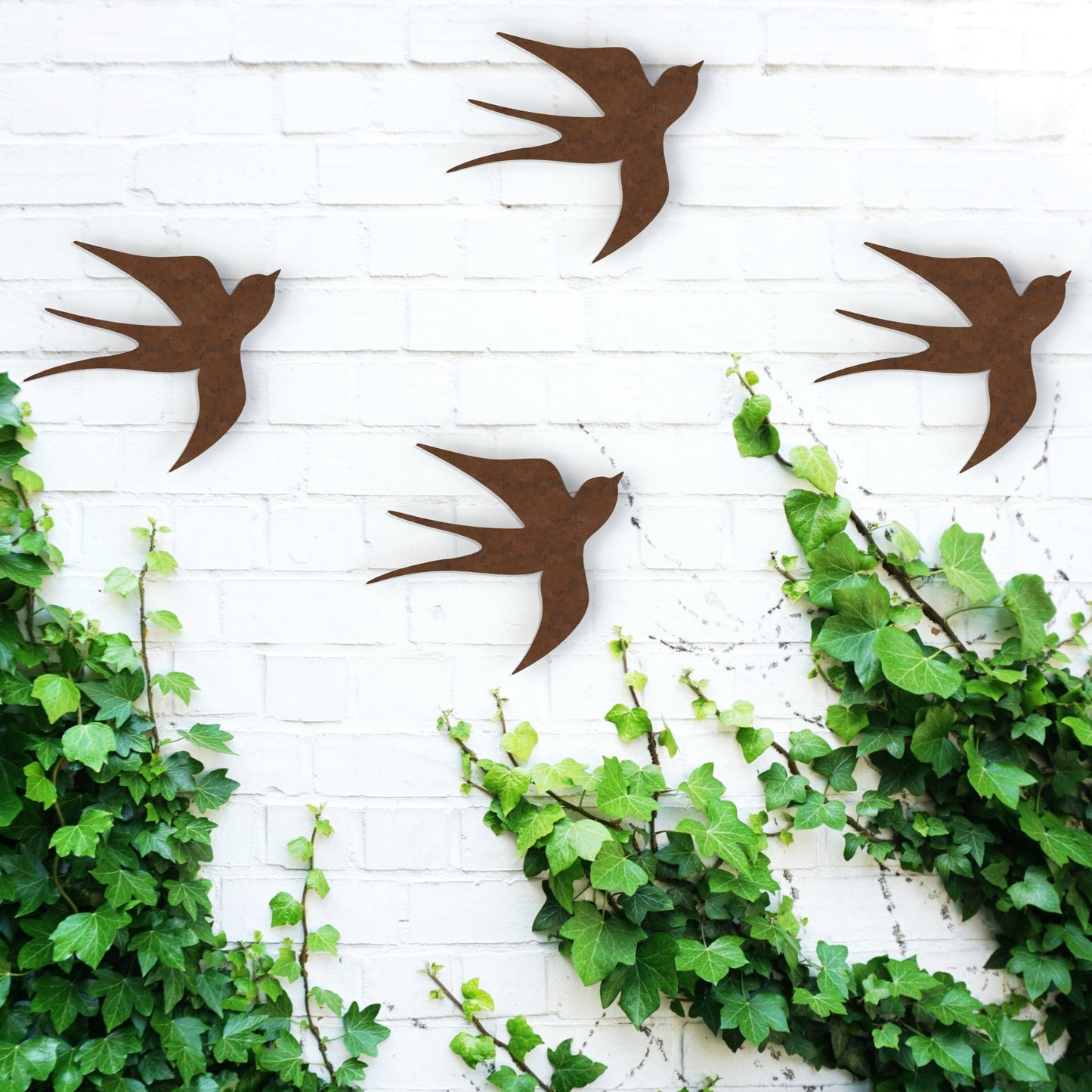 rusty brown swallows set of four hanging on wall in garden