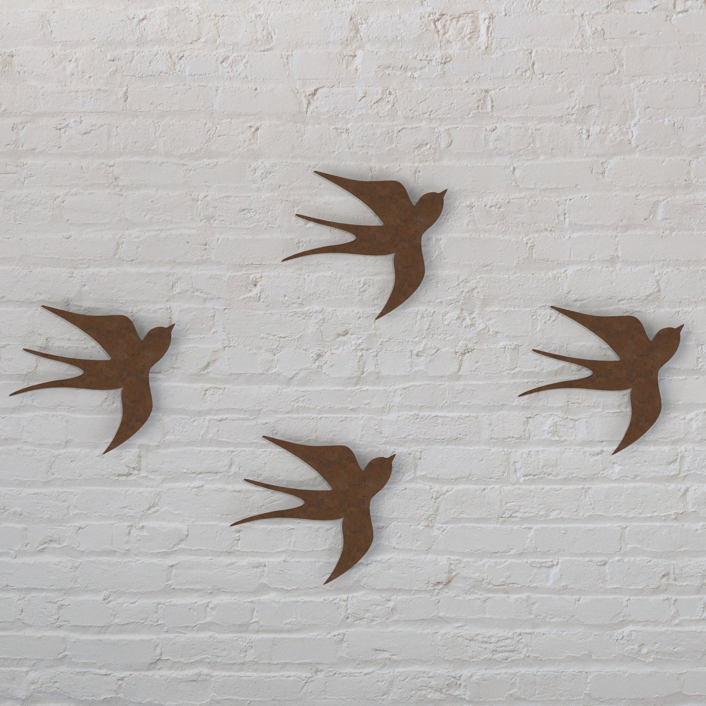 rusty brown swallows set of four hanging on a white brick wall