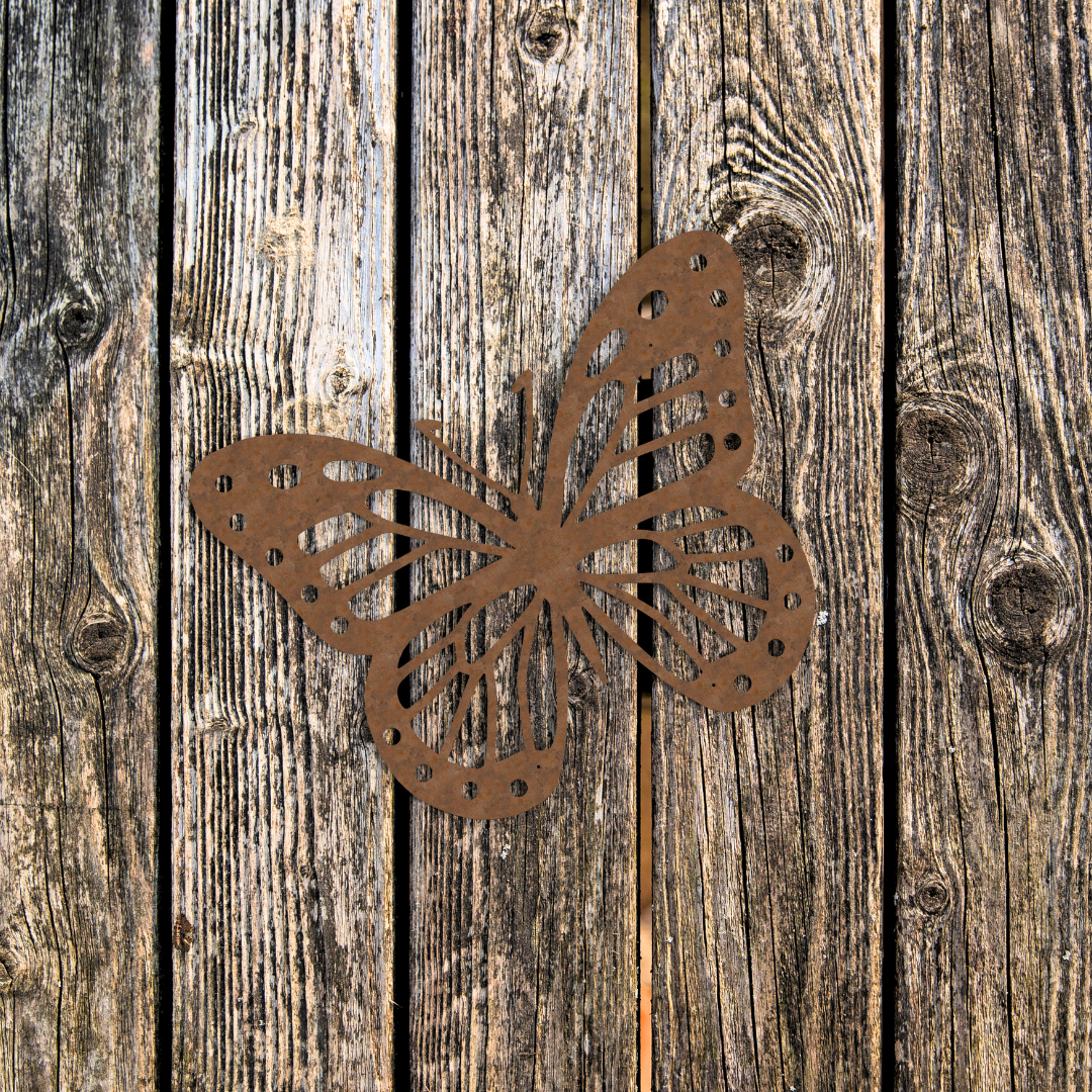 rusty butterfly metal garden ornament on a wooden door