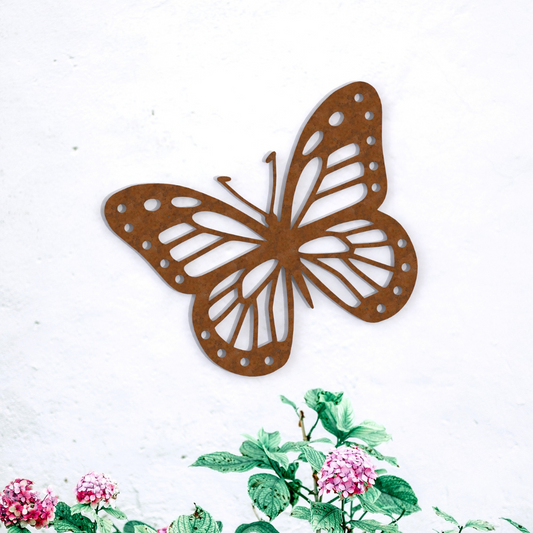 rusty butterfly metal garden ornament on a white wall