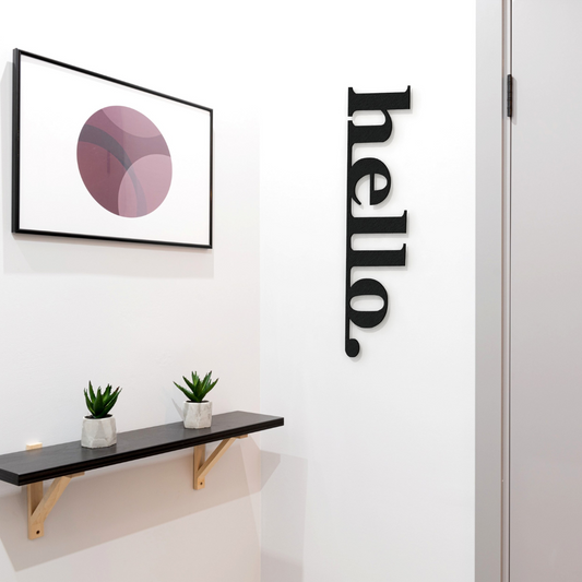 black hello metal sign on wall in hallway