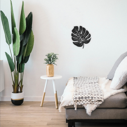 black monstera leaf metal wall art on wall in living room