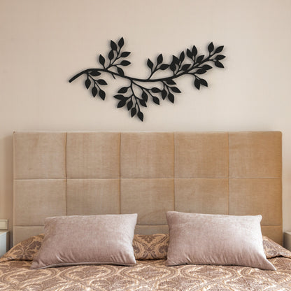 black tree branch with leaves stand-off metal wall art hangs on wall in bedroom