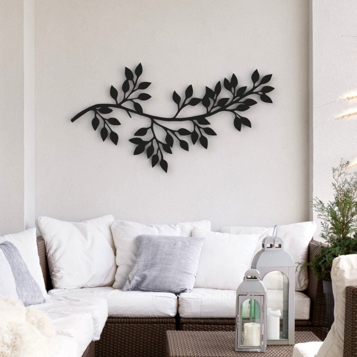 black tree branch with leaves stand-off metal wall art hangs on wall on balcony